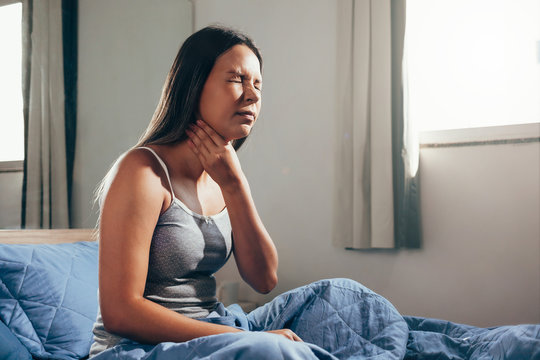 Young Woman Suffering From Sore Throat In Bed