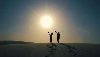 Friends opening arms in Lencois Maranhenses National Park in Brazil