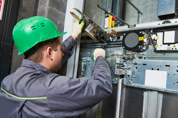 lift machinist adjusting elevator mechanism