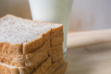 A Glass milk with bread slice on wood background