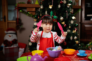 toddler baby girl preparing christmas party in fornt of christmas tree
