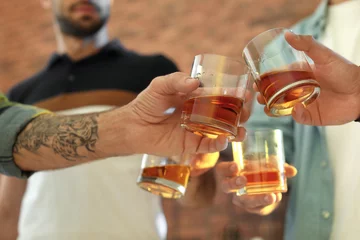 Poster Alcohol Vrienden roosteren met glazen whisky binnenshuis, close-up