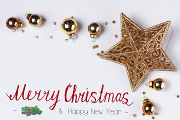 Christmas flat lay styled scene with golden star, copy space on white desk with Merry Christmas...