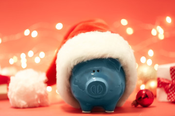 Piggy bank with Santa hat against blurred background