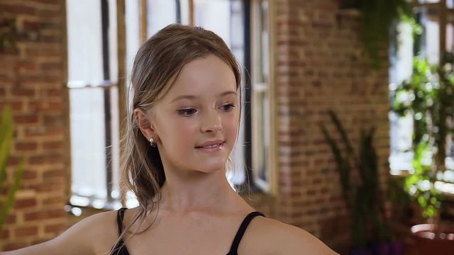 Graceful young ballerina dances on ballet school. Charming teenage girl practice classic ballet moves at the ballroom