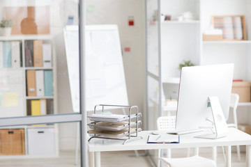Background image of modern office interior with PC on workplace in cubicle separated by glass walls, copy space