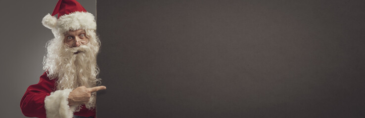 Happy Santa pointing at a blank sign