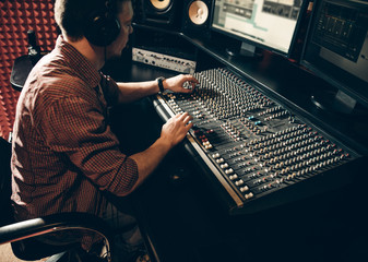 talented guy working in the music studio. man is creating a hit. close up side view photo
