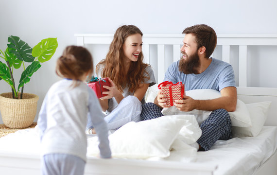 happy family mother, father and child  in bed