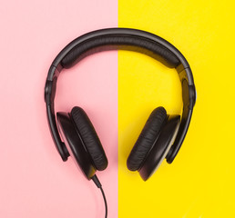 Headphones on pink and yellow background.