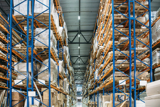 Large Logistics hangar warehouse with lots shelves or racks with pallets of goods