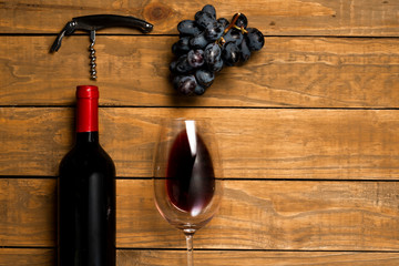 Glasses of wine bottle corks and opener on wooden background. Top view with copy space.