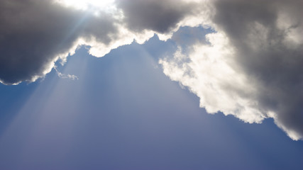 Cloud and a blue sky with rays of sunshine