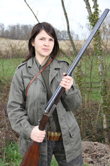 Proud woman hunter holding her vintage shotgun in the field