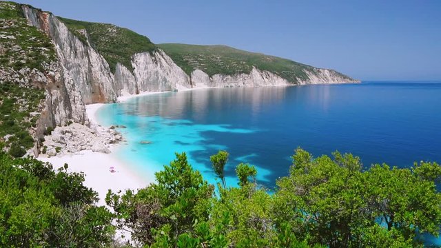 HD video of blue lagoon with rocky coastline, Kefalonia, Greece. Calm clear blue emerald green turquoise sea water. White beach, summer feeling, vacation, travel in paradise. Amazing Ftery beach