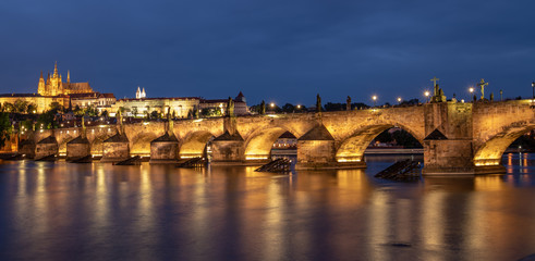 Prague, Czech Republic. Charles Bridge and Hradcany (Prague Castle) with St. Vitus Cathedral and St. George church evening dusk, Bohemia landmark in Praha.