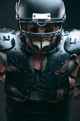 Portrait of athlete - american football player wearing protective shields on bare chest, looking...