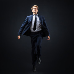 Businessman on a dark background. A leap into the unknown, an ambitious business concept project.