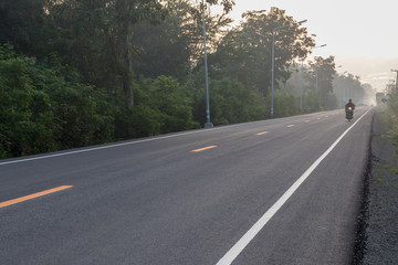 Asphalt road with sun rising in the countryside.