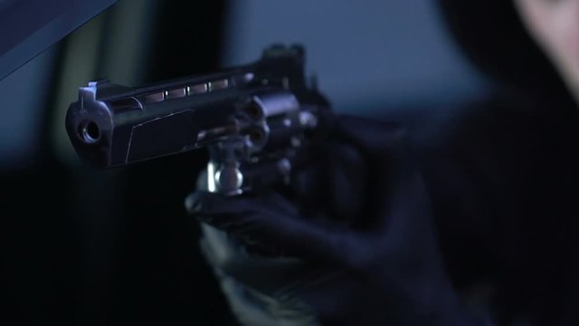 Experienced killer aiming handgun at victim, contract murder crime, danger