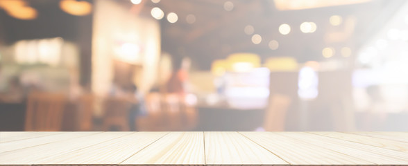Wood table top with Restaurant cafe or coffee shop interior with people abstract defocused blur background