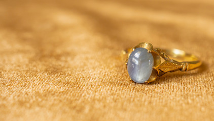 Vintage gold Jewelry blue sapphire ring on fabric texture