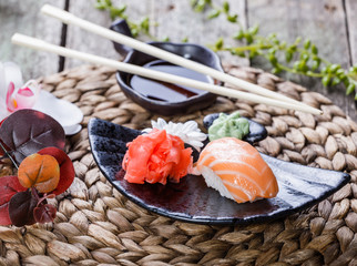 Sushi Set nigiri and sushi rolls decorated with flowers on bamboo background. Japanese cuisine. Selective focus
