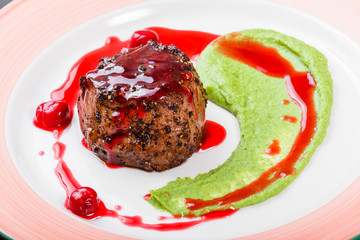 Grilled beef steak meat with berries and avocado sauce in plate. Hot Meat Dishes. Top view, flat lay