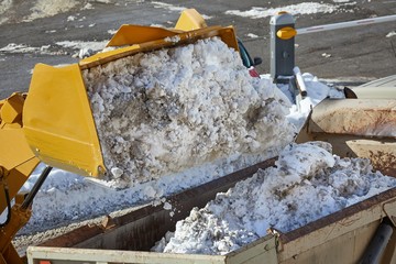 Loader removing snow from street