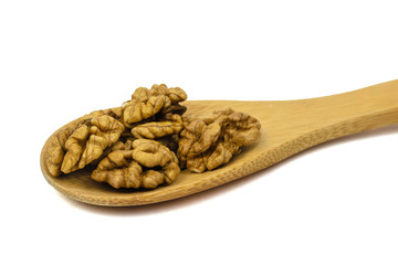 Large wooden spoon with walnuts isolated on white background.