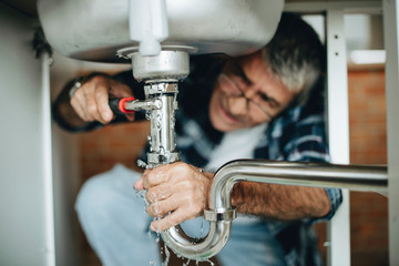 Plumber fixing the kitchen sink