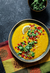 Fresh pumpkin soup topped with parsley and pomegranate seeds
