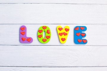 Word Love on wooden background closeup. Concept for Valentines Day background.