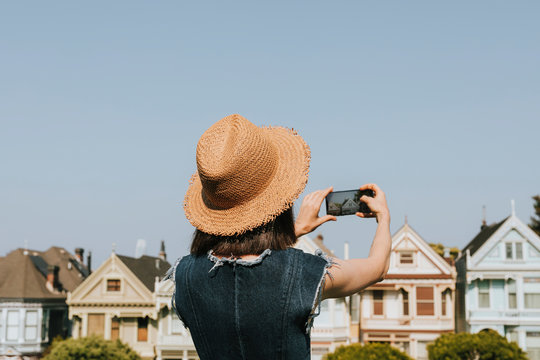 Woman taking a photo of the Painted Ladies of San Francisco, USA