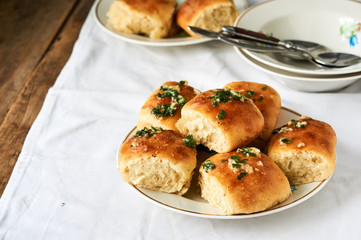 Homemade buns with garlic and fresh herbs on a plate