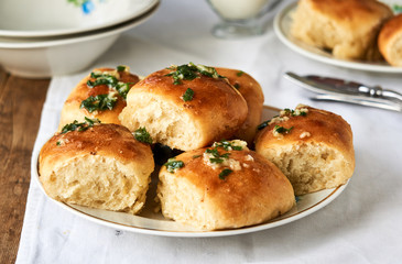 Homemade buns with garlic and fresh herbs on a plate
