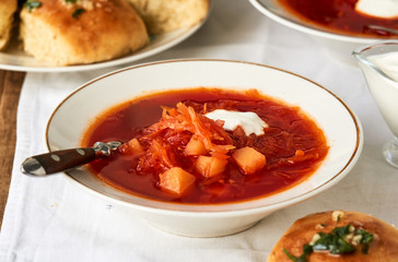 Vegetable beet soup with sour cream in a bowl on a white background