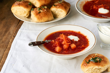 Vegetable beet soup with sour cream in a bowl on a white background