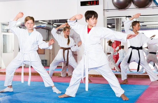 Kids exercising karate movements with trainer