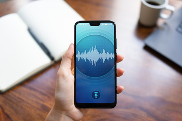 Voice recognition application on smartphone screen. Artificial intelligence and deep learning concept.