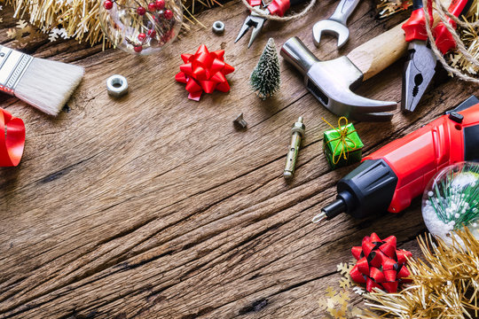 Merry Christmas and Happy New Years Handy Constrcution Tools background concept.  Handy House Fix DIY handy tools with Christmas ornament decoration on a rustic wooden table.