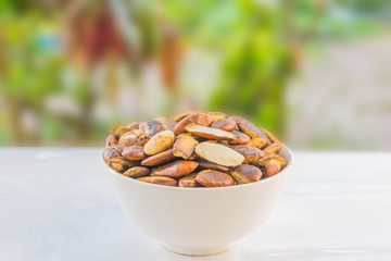 The soft focus grilled, roasted of Irvingia malayana, Irvingiaceae, seeds on the white cup, Local seed food in Thailand.