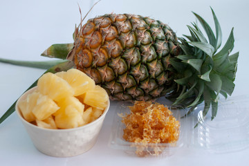 Whole, sliced piece and preserved pineapple isolated on white paper background.