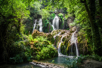 Fototapeta na wymiar Beautiful stream waterfalls cascade over pretty green moss covered stones