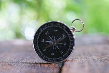 Vintage compass on old wooden table background with smooth blur background, copy space