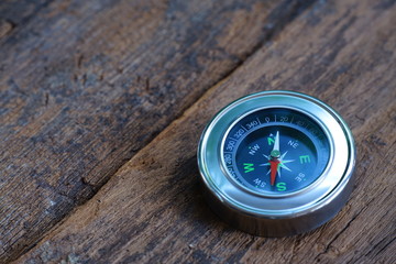 Vintage compass on old wooden table background with smooth blur background, copy space