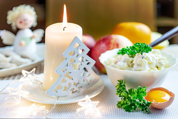 Czech christmas time and customs - bohemian cuisine and typical candle and tree decoration - traditional homemade potato salad prepared for festive dinner