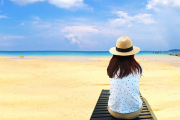 Women sit alone on sleeping chair with background sea beach and blue sky,have space for idea