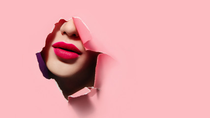 Beautiful red lips in pink paper frame. Plump lips, woman face. Close up portrait - obrazy, fototapety, plakaty