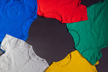 Colorful collection of t-shirts on wooden background